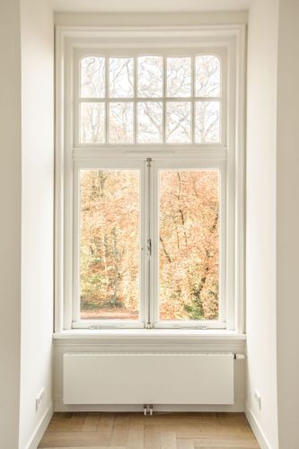 Holzfenster mit Sprossen an einer älteren Hausfassade